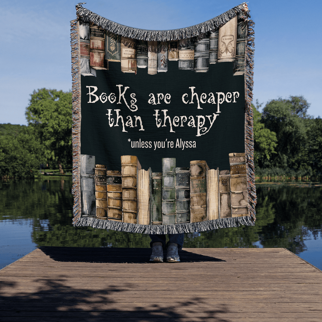 Personalized "Books Are Cheaper Than Therapy" Woven Blanket held up outside – Gift for Introverted Readers - Offbeat Opulence