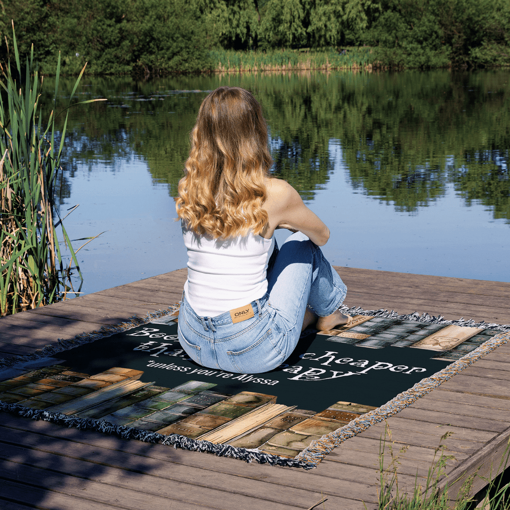 Personalized "Books Are Cheaper Than Therapy" Woven Blanket on a lake dock – Gift for Introverted Readers - Offbeat Opulence